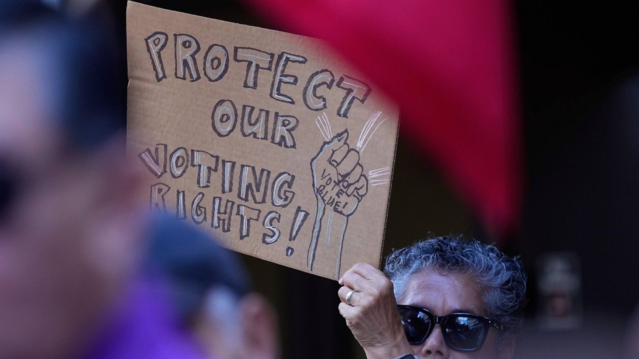 A supporter waves a sign at a news conference, Aug. 26, 2024, in San Antonio. (AP Photo/Eric Gay, file)